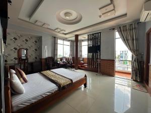 a bedroom with a bed and a living room at SEAMOON Hotel in Rạch Giá