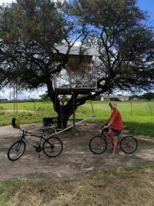 a man standing next to a bike next to a tree at Recanto Família lima e Silva in Garanhuns