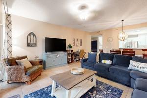 a living room with a blue couch and a table at TOPS'L Summit 210 in Destin