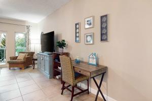 a living room with a desk and a tv at TOPS'L Summit 210 in Destin