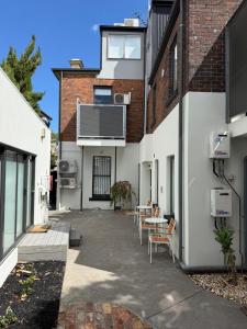 an internal courtyard of a building with tables and chairs at Sixty Two On Grey Serviced Apartments in Melbourne