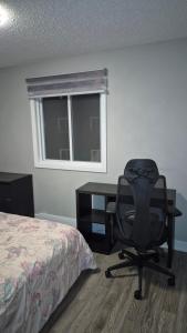 a bedroom with a desk and a chair next to a bed at Messila in Gatineau