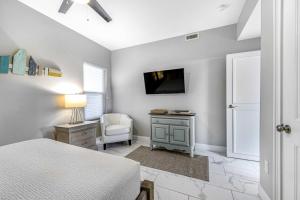 a bedroom with a bed and a tv on a wall at Condo with Shoreline Views and Resort Pools in Destin