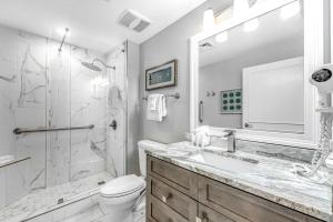 a bathroom with a shower and a toilet and a sink at Condo with Shoreline Views and Resort Pools in Destin