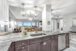 a kitchen with a sink and a living room at Condo with Shoreline Views and Resort Pools in Destin +19 photos