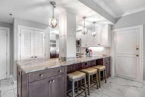 a kitchen with a large counter with stools at Condo with Shoreline Views and Resort Pools in Destin