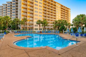 a swimming pool with chairs and a large building at TOPS'L Summit VI in Destin