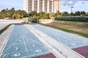 a path in a park with a bench and a building at TOPS'L Summit VI in Destin +30 photos