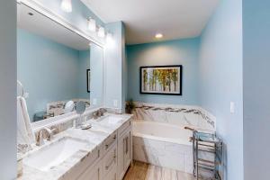 a bathroom with two sinks and a large mirror at TOPS'L Summit 1108A in Destin +10 photos