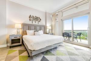 a bedroom with a bed and a large window at TOPS'L Summit 1108A in Destin
