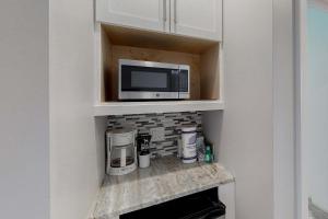 a microwave sitting on a shelf in a kitchen at TOPS'L Summit 1108A in Destin