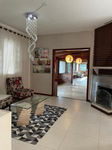 a living room with a glass table and a fireplace at Refúgio Alto do Pinhal in Santo Antônio do Pinhal
