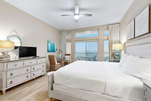 a bedroom with a large white bed and a balcony at Top-Floor Studio with Ocean Views and Pool in Destin