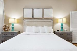 a bedroom with a large white bed with two lamps at Top-Floor Studio with Ocean Views and Pool in Destin