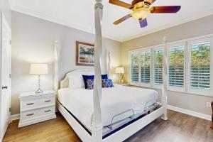 a bedroom with a white bed and a ceiling fan at TOPS'L Summit 107b in Destin