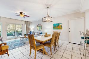 a dining room and living room with a table and chairs at TOPS'L Summit 107b in Destin