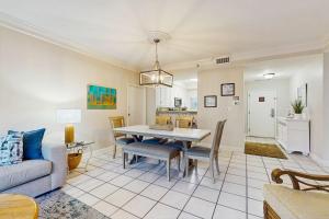 a dining room and living room with a table and chairs at TOPS'L Summit 107b in Destin