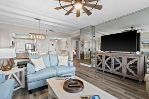 a living room with a blue couch and a flat screen tv at TOPS'L Summit 809 2 Bedroom in Destin