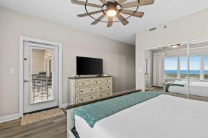a bedroom with a bed and a flat screen tv at TOPS'L Summit 809 2 Bedroom in Destin