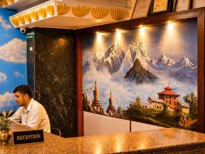 a man sitting at a table in front of a mural at Hotel Woodland Kathmandu in Kathmandu +60 photos