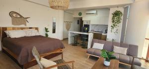 a bedroom with a bed and a couch and a kitchen at Coral Loft in Antón Lizardo