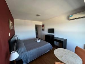 a hotel room with a bed and a table at Hotel Atlántico Suites in Mar del Plata