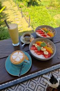 a table with three plates of food and a cup of coffee at Coco Verde Bali Resort in Tanah Lot
