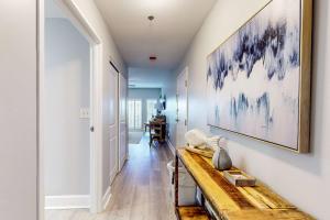 a hallway with a wooden bench and a painting on the wall at 4th-Floor Condo with Shared Pool and WiFi in Destin