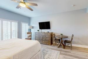 a bedroom with a bed and a table with a tv at 4th-Floor Condo with Shared Pool and WiFi in Destin