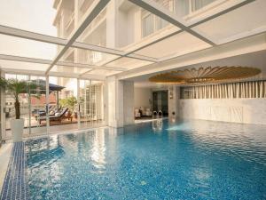a swimming pool in a building with a swimming pool at Hotel de l'Opera Hanoi - MGallery in Hanoi