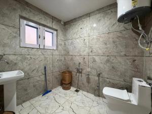 a bathroom with a toilet and a sink and a window at FarahBakshResidency in Jāmb +34 photos