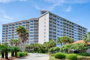 a large white apartment building with palm trees at TOPS'L Summit II in Destin