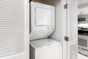 a kitchen with a white refrigerator and a microwave at TOPS'L Summit II in Destin +15 photos