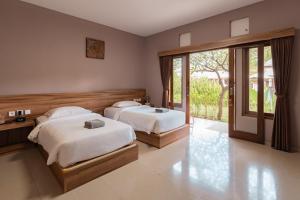a bedroom with two beds and a sliding glass door at Gunung Agung Timur in Amed +56 photos