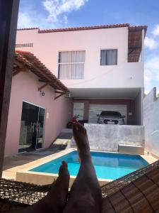 a man laying on a balcony near a swimming pool at Pousada Valley House in Piranhas