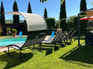 a group of chairs sitting next to a swimming pool at Relax Home Holiday in Panicale