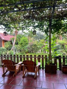two chairs sitting on a patio with a fence at Homestay GETA House in Ấp Thanh Sơn (1)