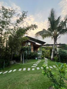 a yard with a house and a palm tree at Homestay GETA House in Ấp Thanh Sơn (1)