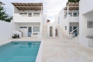 a white house with a swimming pool in front of it at Punta Mayia in Brisas de Zicatela