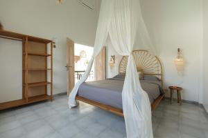 a bedroom with a bed with a mosquito net at Uluwatu - Beach Villa 5 in Uluwatu