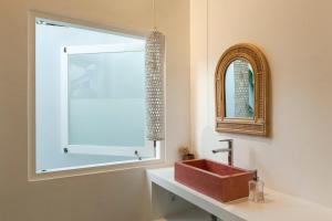 a bathroom with a red sink and a window at Uluwatu - Beach Villa 5 in Uluwatu +18 photos