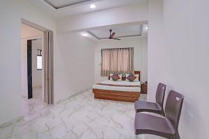 a bedroom with a bed and a chair in it at FabHotel Red Rose Palghar in Nale Sopāra