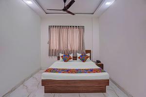 a bedroom with a bed and a ceiling fan at FabHotel Red Rose Palghar in Nale Sopāra
