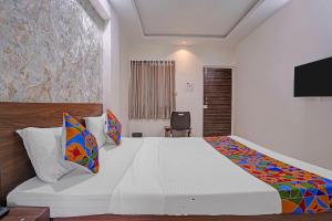 a bedroom with a large bed and a television at FabHotel Red Rose Palghar in Nale Sopāra +20 photos