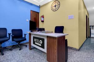 an office with a desk with chairs and a clock on the wall at Super Hotel O Acropolis Mall Kolkata Formerly The Orchid Residency in Kolkata