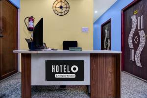 a hotel reception desk with a clock on the wall at Super Hotel O Acropolis Mall Kolkata Formerly The Orchid Residency in Kolkata +37 photos