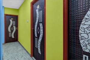 a hallway with two doors with art on the walls at Super Hotel O Acropolis Mall Kolkata Formerly The Orchid Residency in Kolkata