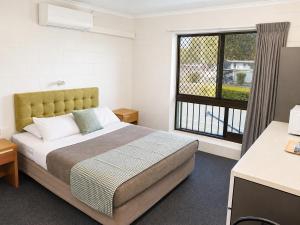 a bedroom with a large bed and a window at Cedar Lodge Motel in Townsville +31 photos