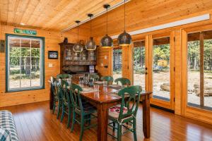 a dining room with a wooden table and green chairs at Pine Acres by NW Comfy Cabins in Leavenworth