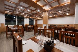 a dining room with wooden tables and chairs at Avasa Boutique Hotel Manali in Manāli +16 photos